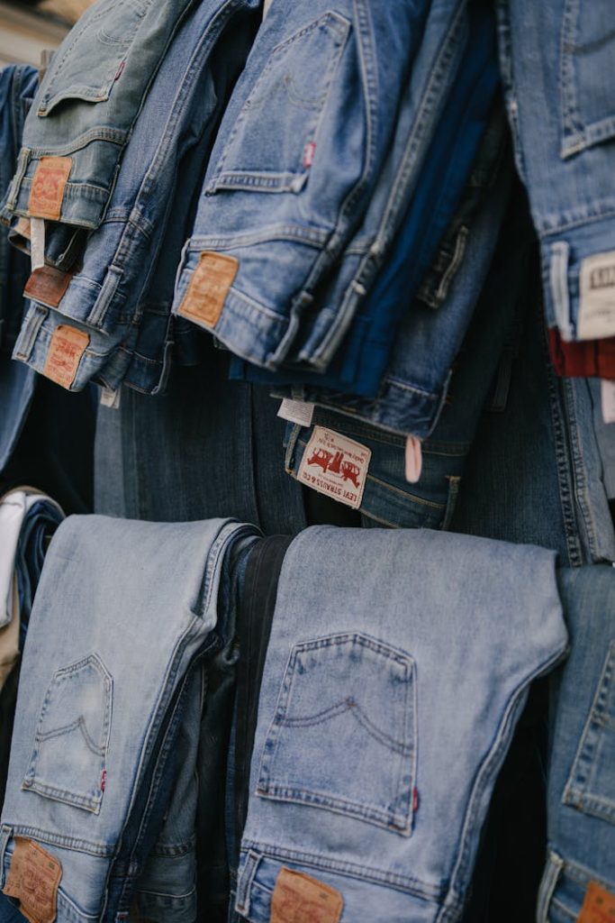 Folded and hanging jeans in a clothing store in Madrid, showcasing fashion variety.