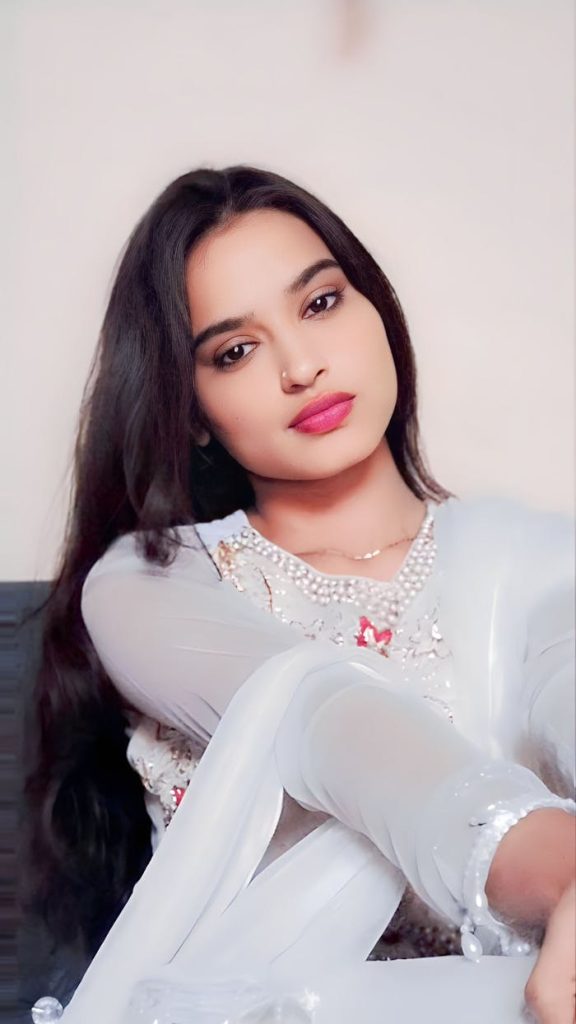 Beautiful woman posing gracefully in traditional white attire.